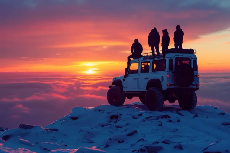 Grupo viendo el atardecer desde un todoterreno en la nieve